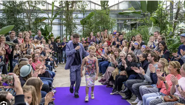 Kind met gastdocent op modeshow